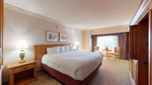 リノにあるReno Suites Hotelの大きなベッドとデスクが備わるホテルルームです。