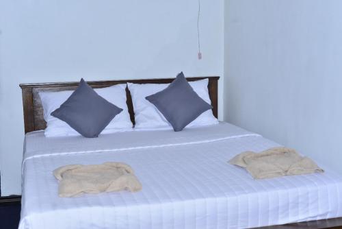 a white bed with pillows and towels on it at YaYa Lodge Haputale in Haputale
