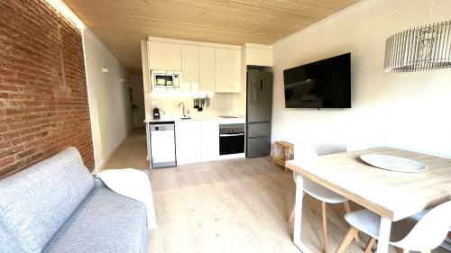a living room with a table and a kitchen at Centro con terraza blco by Prestigi in Terrassa