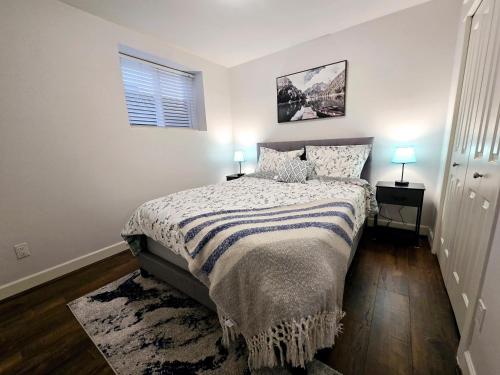 a bedroom with a bed and a window and two lamps at walkout suite in willoughby in Langley
