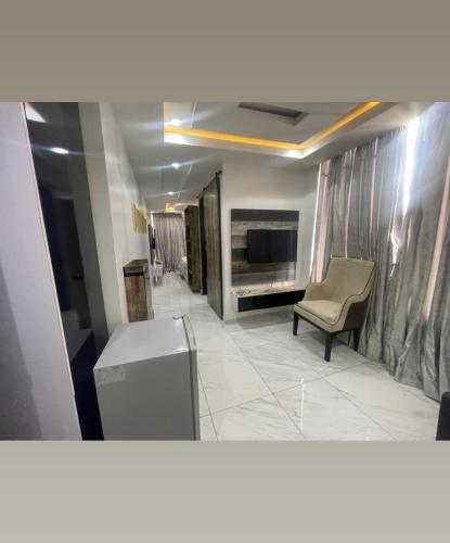 a living room with a television and a chair at Ujuu apartment in Lekki