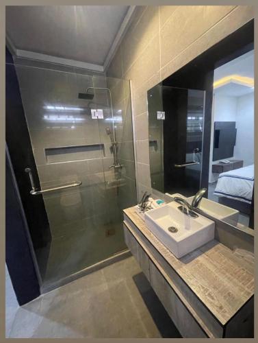 a bathroom with a sink and a shower with a mirror at Ujuu apartment in Lekki