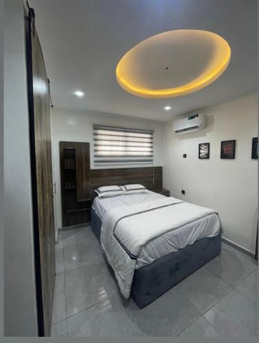 a bedroom with a large bed with a yellow ceiling at Ujuu apartment in Lekki