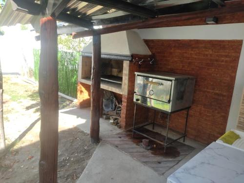 an outdoor kitchen with a stove and a tv at Salon para eventos o reunion empresarial in Plottier
