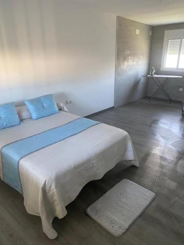 een slaapkamer met een groot bed met blauwe kussens bij Casa campo golf in Chiclana de la Frontera