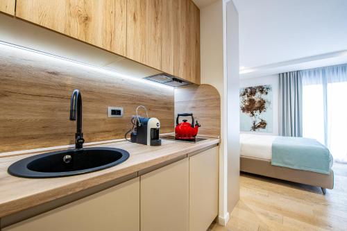 a kitchen with a sink and a bed in a room at Marina Studio Apartment in Herceg-Novi