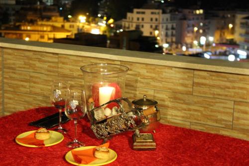 einen Tisch mit Kerzen und Teller mit Speisen und Weingläsern in der Unterkunft Tempio del Sole in Rom