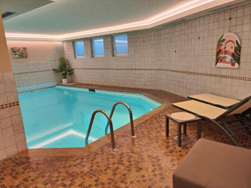 una piscina con una mesa y un banco frente a ella en Hotel Alpenblick, en Sarentino