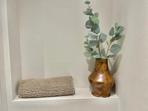 a vase sitting on a shelf with a plant in it at Acariciando la Catedral Vista espectacular in Burgos