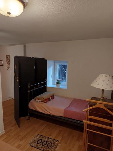 - une chambre avec un lit et une armoire noire dans l'établissement les trois grandes portes, à Doué-la-Fontaine