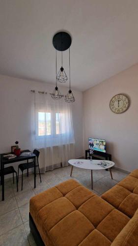 a living room with a couch and a table and a clock at Kofinaki apartment 2 in Tycherón