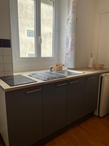 w kuchni z umywalką i oknem w obiekcie Studio cosy Brétigny w mieście Brétigny-sur-Orge