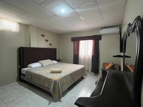 Schlafzimmer mit einem Bett und einem Spiegel in der Unterkunft Elegante apartamento cerca del aeropuerto, Garzota in Guayaquil