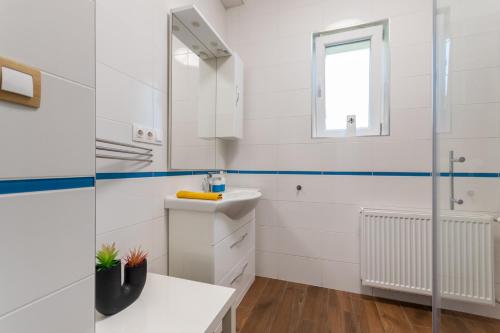 a white bathroom with a sink and a mirror at B12 Apartment Budapest in Budapest