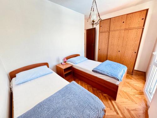 a bedroom with two beds and a chandelier at Dalmatian House, spacious stone terraces, balcony , views in Dubrovnik