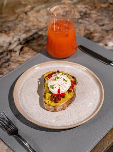 a plate with a piece of bread with an egg on it at HCM - Hotel Corais de Manaira in João Pessoa