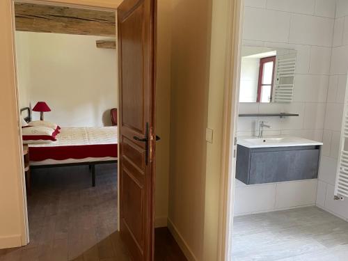 ein Badezimmer mit einem Waschbecken und ein Schlafzimmer mit einem Bett in der Unterkunft La Maison des Poètes 6 personnes à Treigny Perreuse in Perreuse