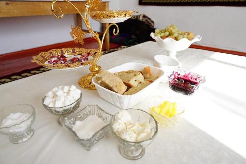 a table topped with bowls and plates of food at Guest House Bereke in Kyzart village in Bagysh