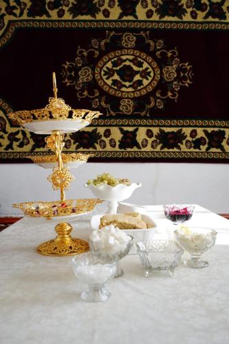 a table with a white table cloth with a plate of food at Guest House Bereke in Kyzart village in Bagysh