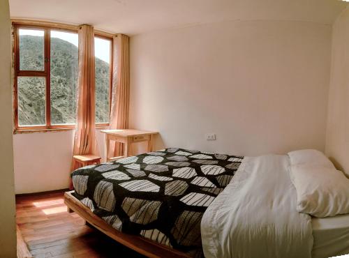 um quarto com uma cama e uma grande janela em Backpackers-balcones-river-lodge em Baños
