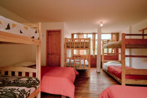 a room with four bunk beds in a house at Backpackers-balcones-river-lodge in Baños