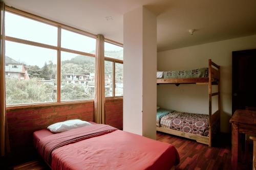 a bedroom with a bunk bed and a window at Backpackers-balcones-river-lodge in Baños