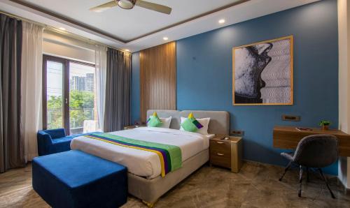 um quarto com uma cama e uma parede azul em The Embassy Inn em Noida
