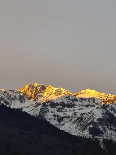 un groupe de montagnes couvertes de neige sur lesquelles le soleil brille dans l'établissement Gite de l'Ours, à Saint-Mamet