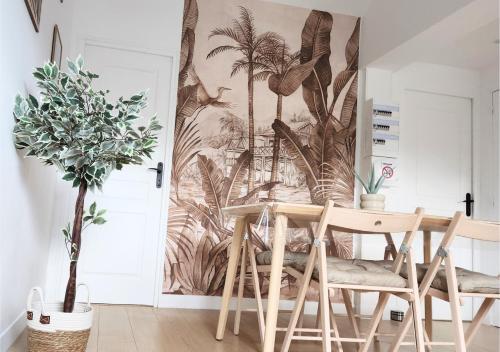 une salle à manger avec une table et une fresque murale de palmiers dans l'établissement Top Central Tours - Vue Basilique Saint Martin, à Tours