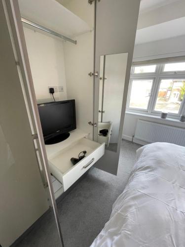 a bedroom with a bed and a tv and a mirror at Grey Home Near wembley arena in Wealdstone