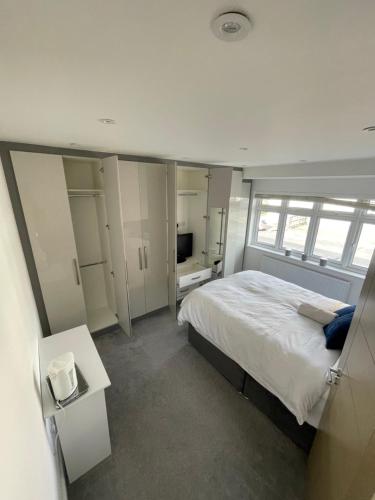 Grey Home Near wembley arena في Wealdstone: غرفة نوم بسرير كبير وتلفزيون