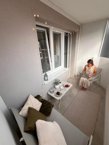a woman sitting in a chair in a room with a laptop at Luxury Apartment PECKA in city centre in Martin
