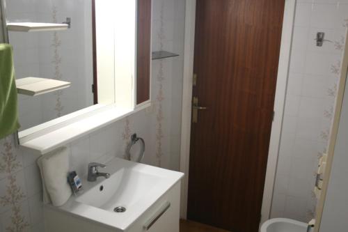 a bathroom with a sink and a mirror and a toilet at Apartamento en primera linea de mar en Pals 306-1 2H in Pals