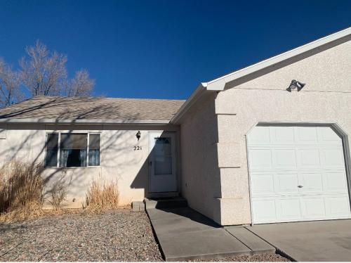 a house with a white garage with a door at Lovely 2- Bedroom Duplex in Pueblo West in Pueblo West
