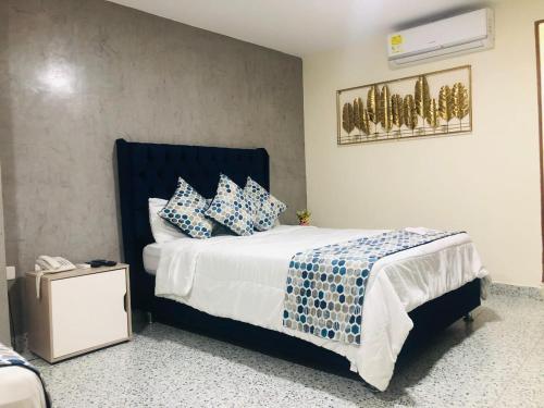 una camera da letto con un letto con cuscini blu e bianchi di Luka Cartagena a Cartagena de Indias