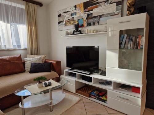 una sala de estar con un gran centro de entretenimiento blanco en Paradise en Pula
