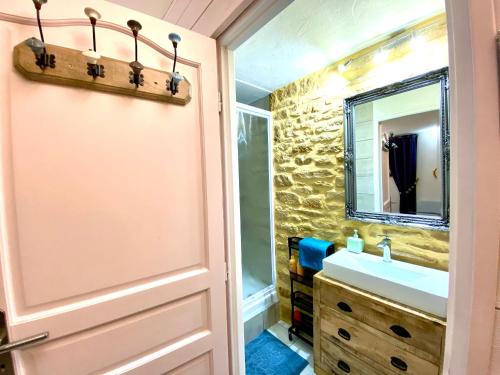 La salle de bains est pourvue d'un lavabo et d'un miroir. dans l'établissement La Clef des Songes B&B de charme - Sarlat Centre - Parking gratuit - Piscine et espace bien-être à 400mètres, à Sarlat-la-Canéda