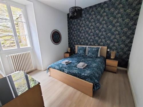 um quarto com uma cama com um edredão azul em Appartement BLUEMA 2 chambres RdC em Vitré