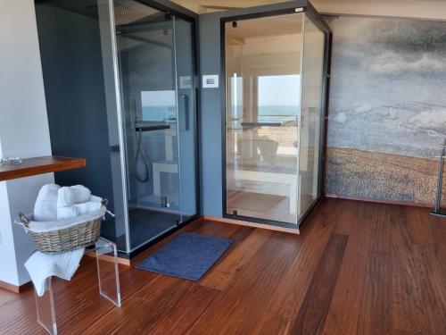 a glass shower in a room with a wooden floor at Colle degli ulivi Green Resort in Petacciato