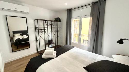 a bedroom with a large white bed and a mirror at Centro con terraza blco by Prestigi in Terrassa