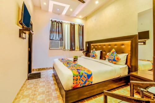 ein Schlafzimmer mit einem großen Bett und einem Flachbild-TV in der Unterkunft Hotel Living Rooms- BY Hotel Green Snapper in Neu-Delhi