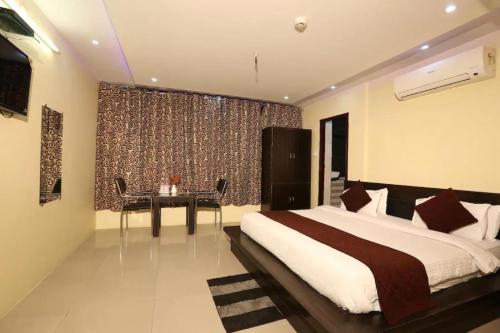 ein Schlafzimmer mit einem Bett und einem Tisch in einem Zimmer in der Unterkunft Hotel Living Rooms- BY Hotel Green Snapper in Neu-Delhi