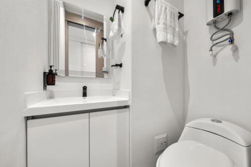 een witte badkamer met een wastafel en een toilet bij FH - Technological studio in Chico - Bogota in Bogota