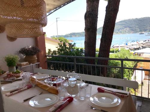 a table with plates and glasses and a view of the ocean at Villa Claudia in Portovenere