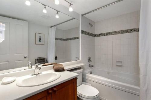 a bathroom with a sink and a toilet and a tub at Cozy Townhouse in Whistler Village North in Whistler