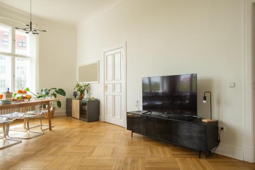 un soggiorno con una grande TV a schermo piatto di K132 bis 10 Personen 155 sqm 3 Bedrooms 2 Bathrooms 2OG Aufzug 2 Balkone Boxspringbetten a Berlino