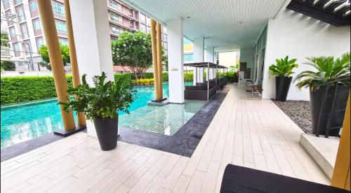 a lobby with a pool in a building with potted plants at "500m from Beach Modern Residence" in Hua Hin