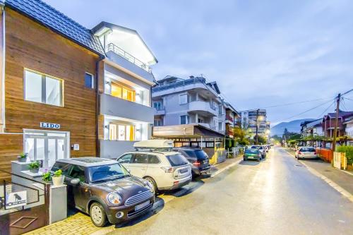 een straat met auto's geparkeerd voor gebouwen bij Apartments Lido in Ohrid