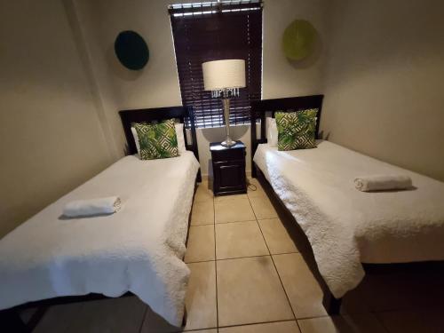 2 camas individuales en una habitación con ventana en Bali Hai, en Westbrook