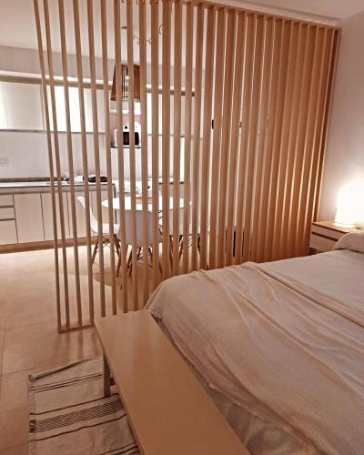 a bedroom with a bed and a wooden wall at Espacio Los Ciruelos Ituzaingo in Ituzaingó